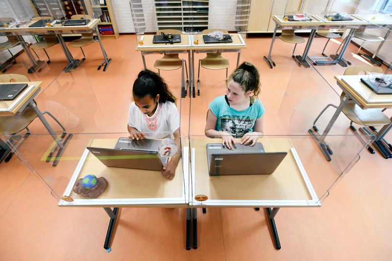 &copy; Reuters. FOTO DE ARCHIVO. Los alumnos sentados detrás de paneles de plexiglás asisten a una clase en una escuela primaria, durante el brote de la enfermedad por coronavirus (COVID-19), en Den Bosch, Países Bajos