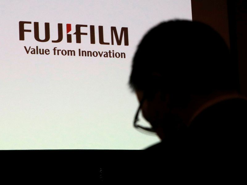 &copy; Reuters. A man is silhouetted in front of Fujifilm Holdings&apos; logo ahead of its news conference in Tokyo