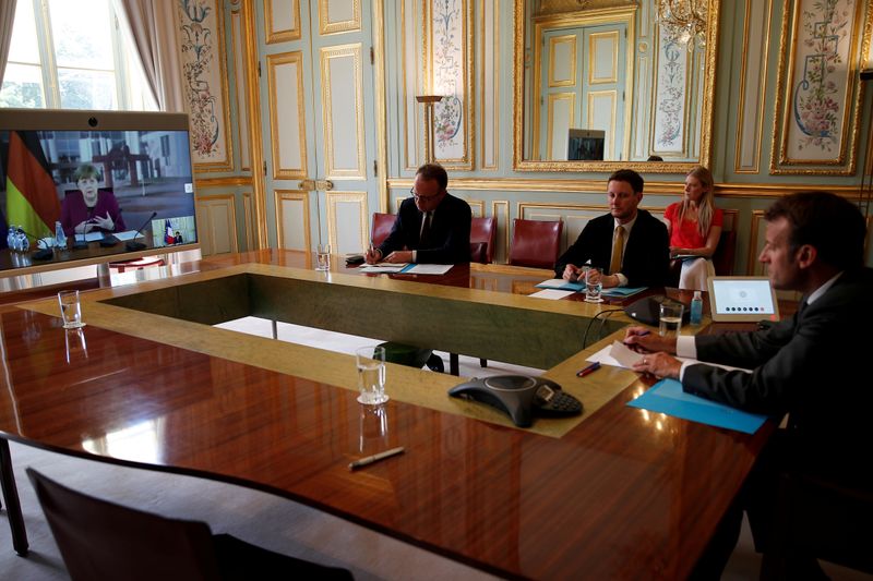 &copy; Reuters. FILE PHOTO: French President Emmanuel Macron listens to German Chancellor Angela Merkel during a video conference at the Elysee Palace