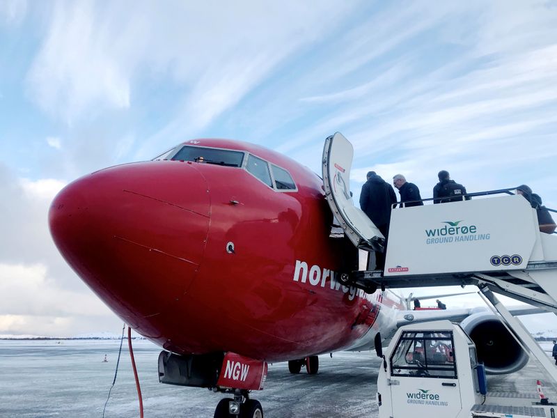 © Reuters. FILE PHOTO: Passengers board a Norwegian Air plane in Kirkenes