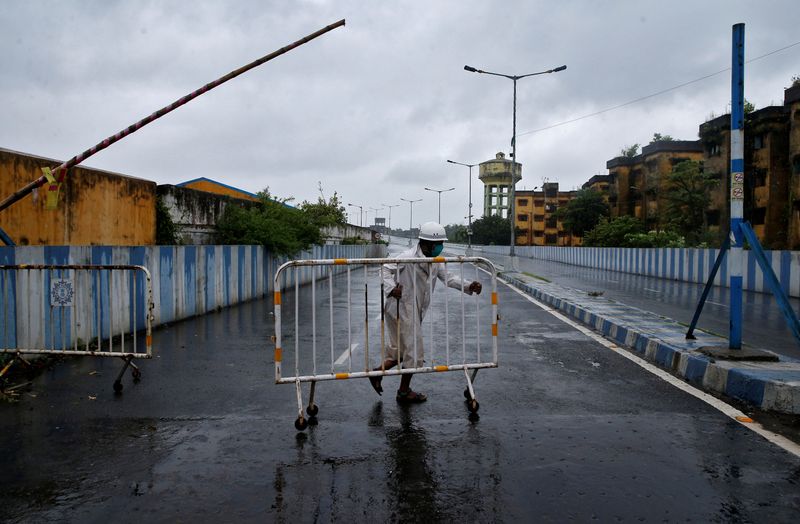 &copy; Reuters. Un oficial de policía mueve una barricada para bloquear un camino antes de que el ciclón Amphan toque tierra, en Calcuta, India, el 20 de mayo de 2020