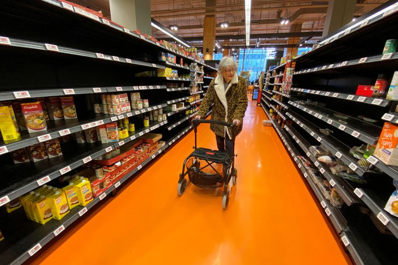 © Reuters. FILE PHOTO: A shopper walks through an aisle empty of pasta, rice, beans and soup at a Loblaws supermarket in Toronto