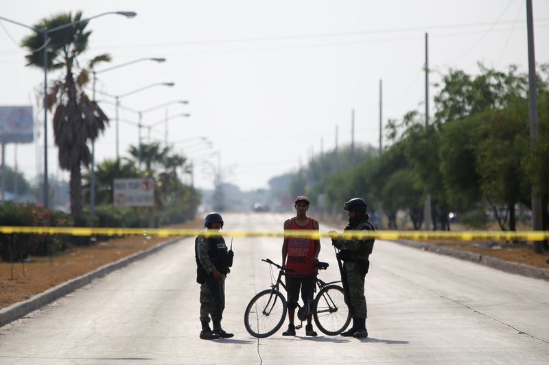 &copy; Reuters. FILE PHOTO: Soldiers talks to a man at a crime scene after unknown assailants attacked a workshop leaving several casualties, according to local media, in Celaya