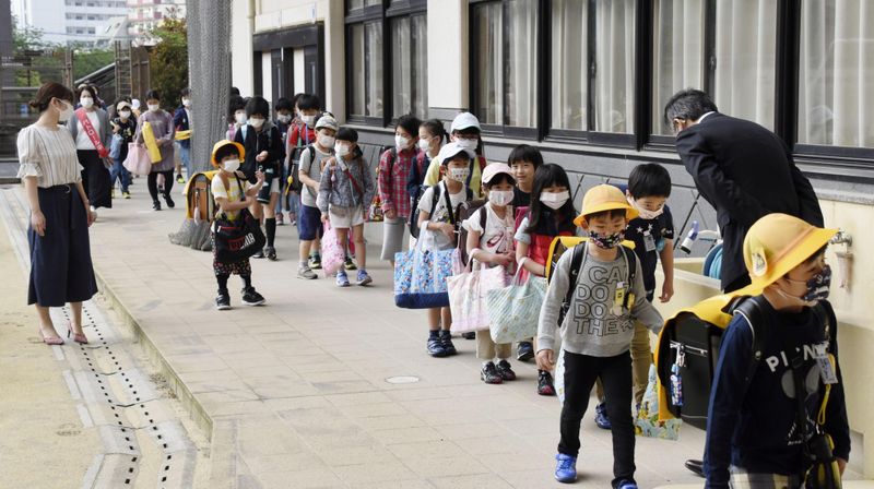 © Reuters. Crianças utilizam máscaras de proteção contra o coronavírus em frente a escola em Nagasaki, Japão