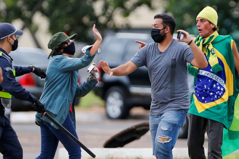&copy; Reuters. Briga entre manifestante de oposição e manifestantes de apoio ao presidente Jair Bolsonaro em Brasília