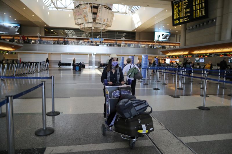 © Reuters. FILE PHOTO: A woman walks through the empty international terminal at LAX airport in Los Angeles