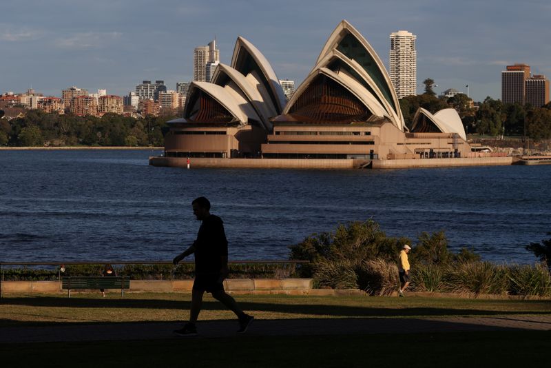 &copy; Reuters. People stroll through a park in front of the Sydney Opera House in Sydney