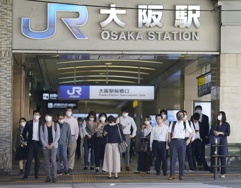 &copy; Reuters. Viajeros con mascarillas se dirigen a trabajar en Osaka, Japón