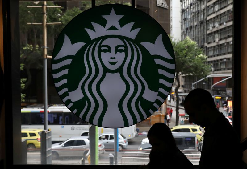 &copy; Reuters. Customers pass by the logo of an American coffee company Starbucks inside a coffee shop in Rio de Janeiro