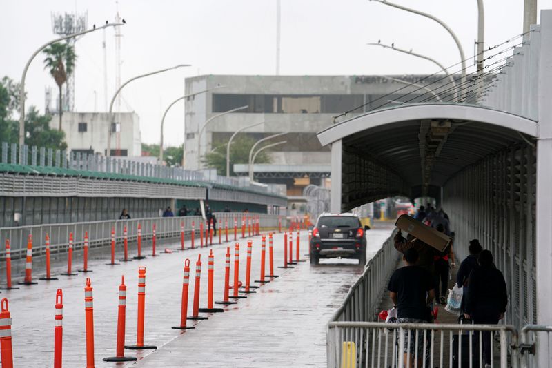 © Reuters. FILE PHOTO: People cross towards Mexico as efforts to try to slow the spread of the coronavirus disease continues in Laredo