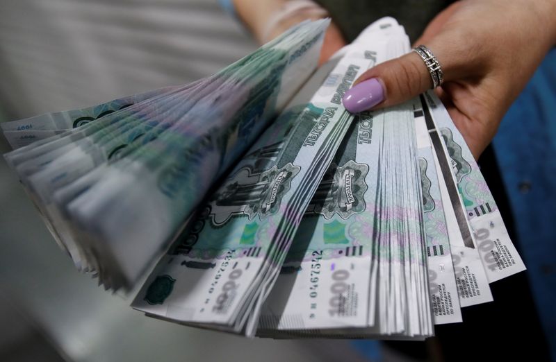 © Reuters. An employee holds 1000 Russian Roubles notes at Goznak printing factory in Moscow