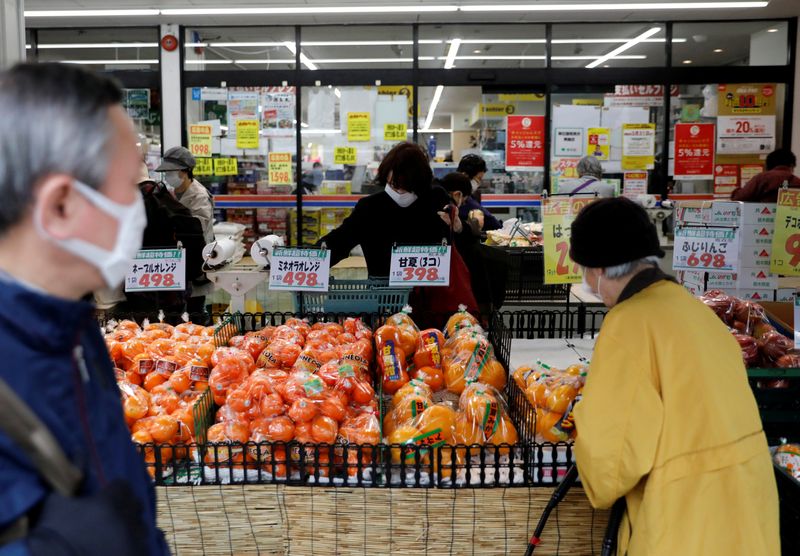 © Reuters. FILE PHOTO: Shoppers wearing protective face masks, following an outbreak of the coronavirus disease, are seen at a supermarket in Tokyo, Japan