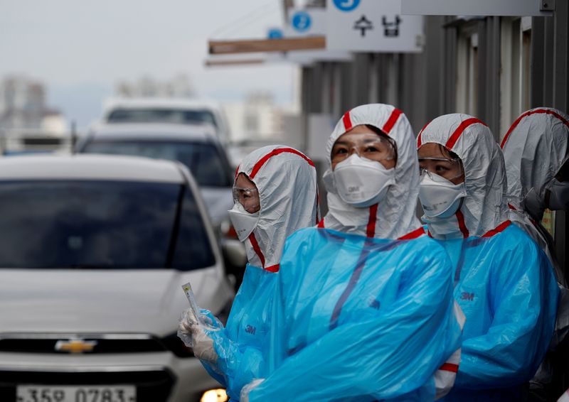 &copy; Reuters. FILE PHOTO: FILE PHOTO: Medical staff in protective gear work at a &apos;drive-thru&apos; testing center for the novel coronavirus disease of COVID-19 in Yeungnam University Medical Center in Daegu