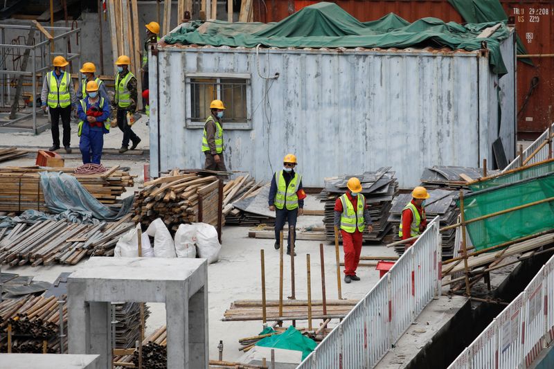 © Reuters. Trabalhadores usando máscara em local de construção de Pequim