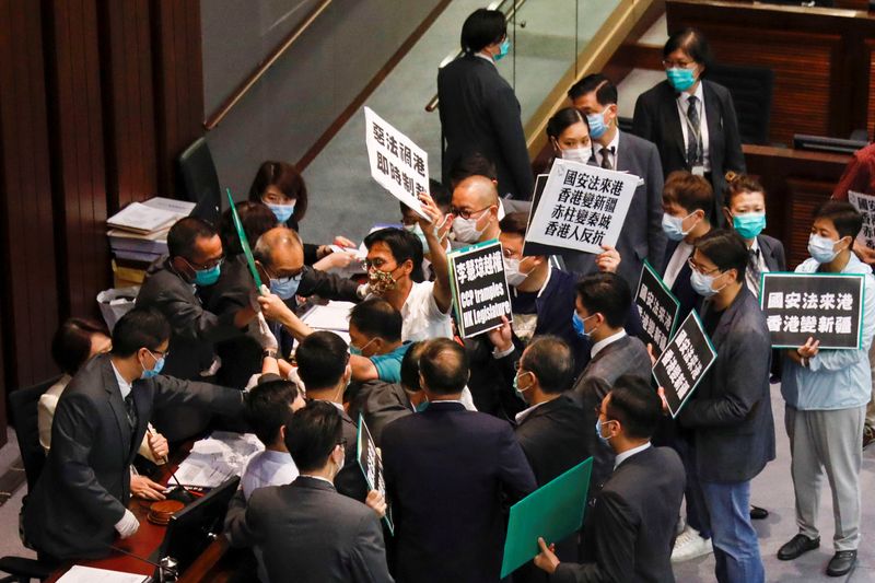 © Reuters. Pan-democratic legislators scuffle with security as they protest against new security laws during Legislative Council’s House Committee meeting, in Hong Kong