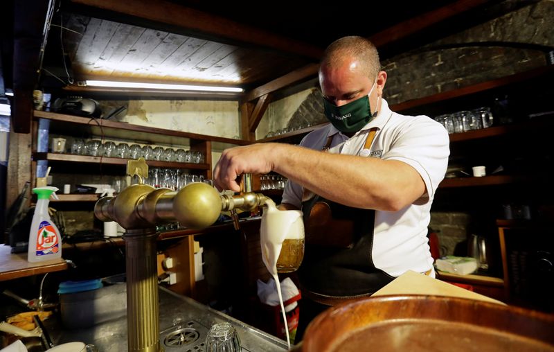 © Reuters. A bartender drafts a glass of beer at an outdoor seating of a pub in Prague