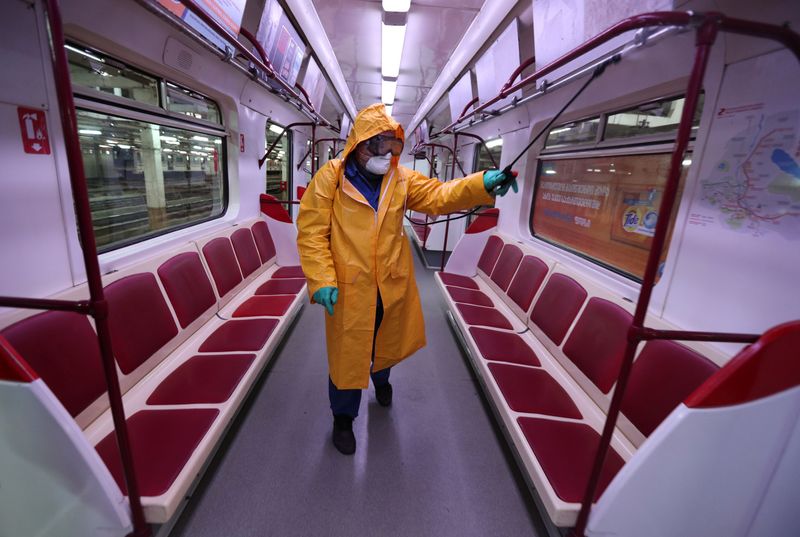 &copy; Reuters. Сотрудник в защитном костюме дезинфицирует вагон метро в Тбилиси
