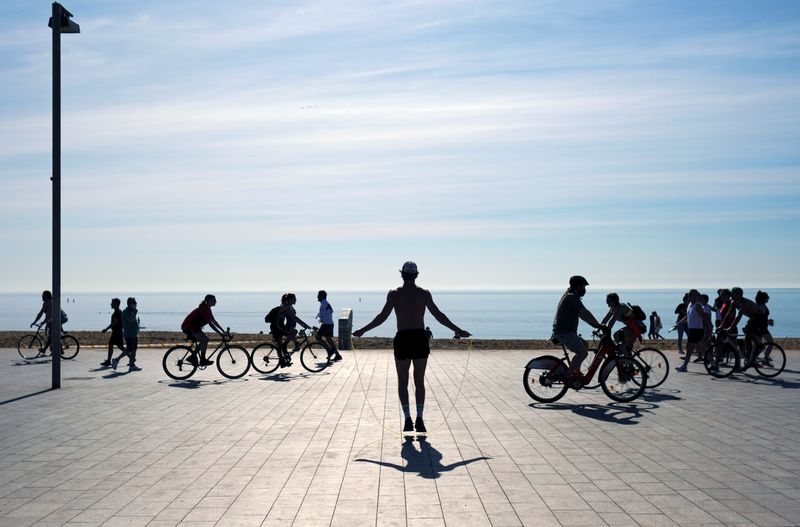 © Reuters. Gente haciendo deporte en la playa de la Barceloneta, durante las horas en las que se permite el ejercicio individual al aire libre, en Barcelona, España