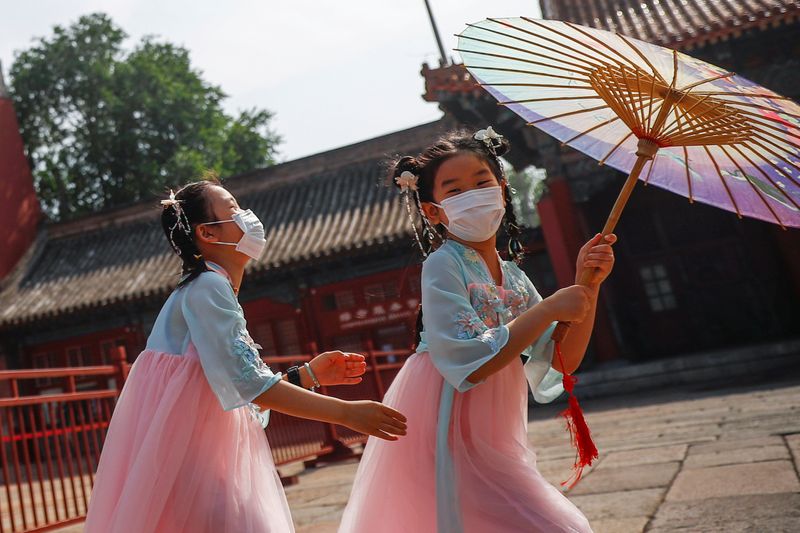 &copy; Reuters. Crianças com máscara brincam perto da entrada da Cidade Proibida, em Pequim