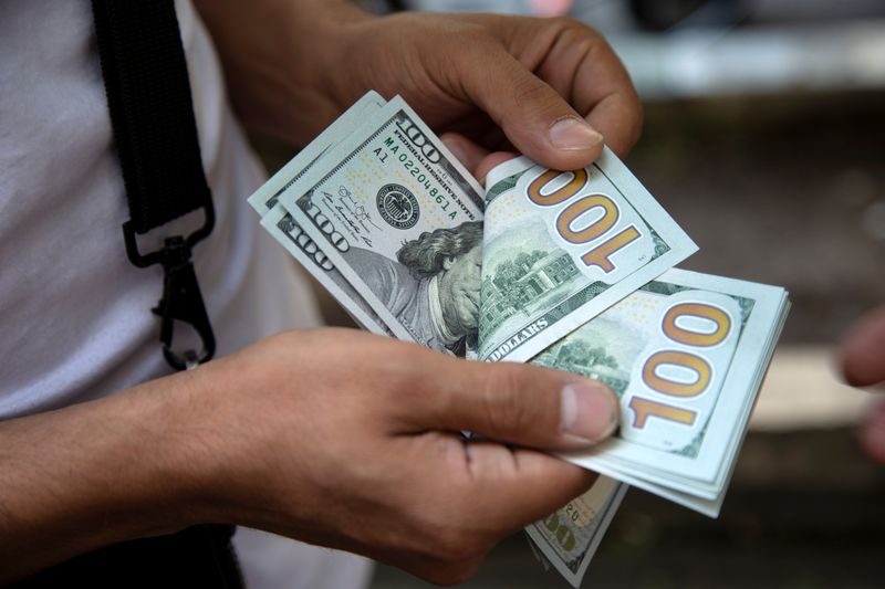 © Reuters. A man counts U.S. dollars in Tehran