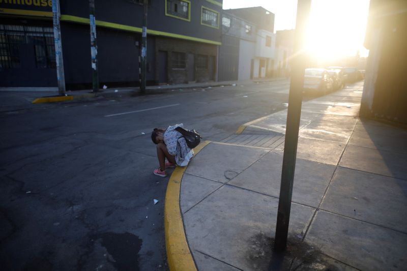 &copy; Reuters. Una persona espera en la calle mientras a ser examinado por la enfermedad coronavirus (COVID-19) y se le permite regresar a su hogar en otra parte del país, en Lima, Perú.