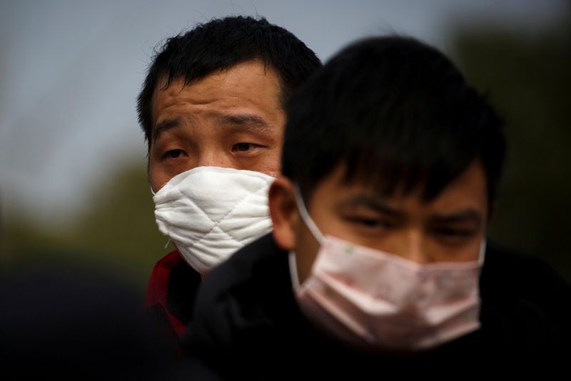 &copy; Reuters. FILE PHOTO: People coming from the Hubei province wait at a checkpoint at the Jiujiang Yangtze River Bridge in Jiujiang