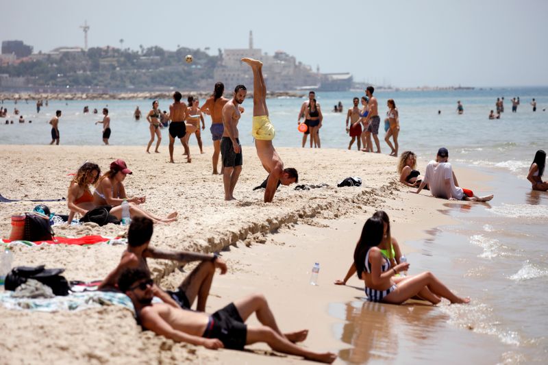 &copy; Reuters. People visit a beach along the coast of the Mediterranean Sea during a heatwave in Israel as restrictions following the coronavirus disease (COVID-19) ease around the country, in Tel Aviv