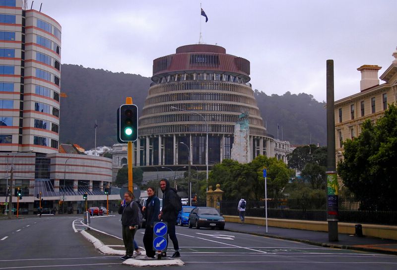 &copy; Reuters. Pedestrians walk across a road in front of the New Zealand parliament building known as the Beehive in central Wellington, New Zealand