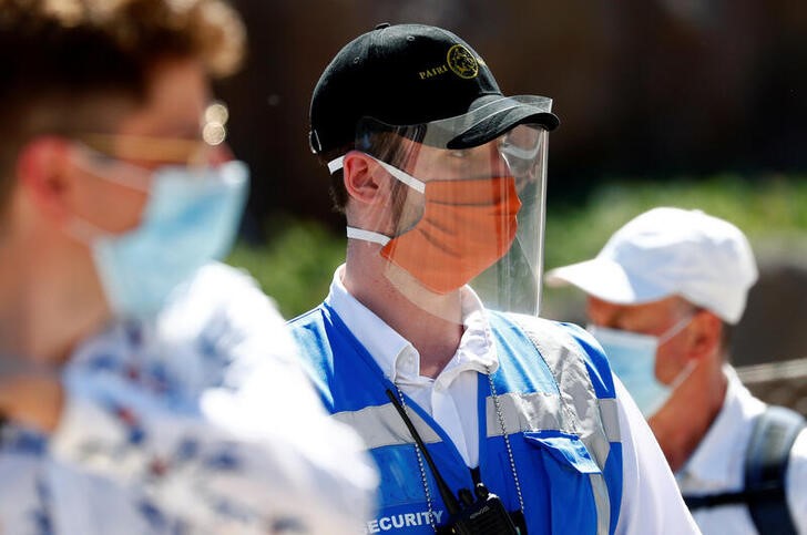 &copy; Reuters. Un membro del personale di sicurezza indossa una maschera protettiva e una visiera al parco faunistico Pairi Daiza, zoo e un giardino botanico di Brugelette, mentre il Paese si prepara ad allentare le misure di contenimento anti-coronavirus, 18 maggio 202