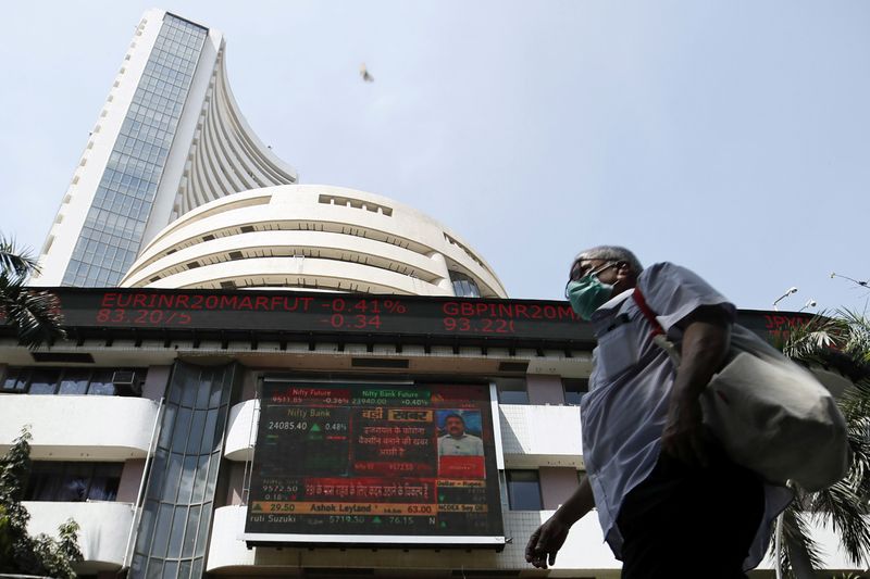 &copy; Reuters. A man wearing a protective mask walks past the Bombay Stock Exchange (BSE) building in Mumbai