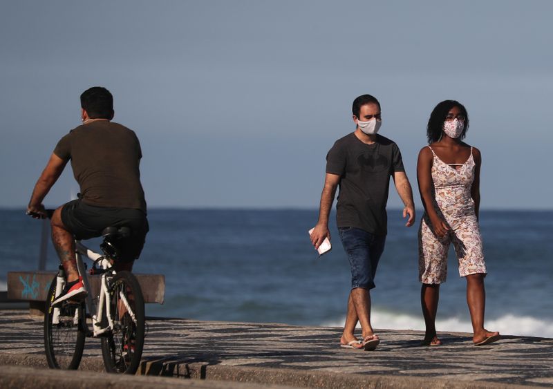 &copy; Reuters. Una pareja camina junto a la playa de Leblon, en medio del brote de coronavirus en Río de Janeiro. Brasil. 25 de mayo de 2020.