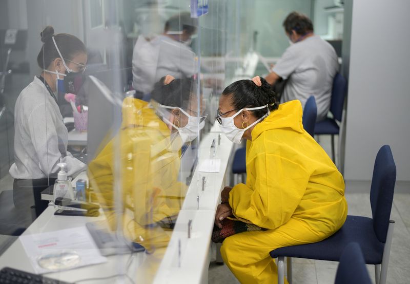 &copy; Reuters. Foto de archivo: un cliente con mascarilla es atendido en una oficina en Guayaquil,  ciudad que permitió que algunas empresas reabrieran  después de una caída de las muertes diarias debido al brote de COVID-19). Guayaquil, Ecuador. 20 mayo 2020