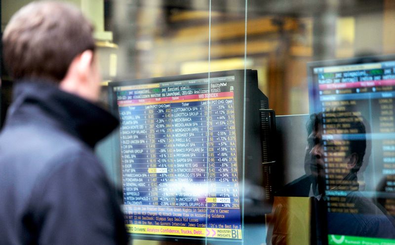 &copy; Reuters. Un uomo controlla l&apos;andamento degli indici di borsa fuori da una banca in centro a Milano