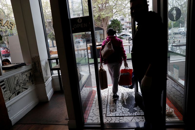 &copy; Reuters. FILE PHOTO: An employee of Farley’s East cafe, that closed due to the financial crisis caused by the coronavirus disease (COVID-19), carries donated food items after being laid off from the cafe in Oakland