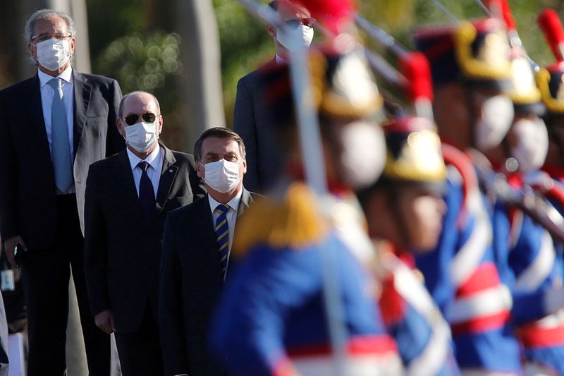 © Reuters. FILE PHOTO: Brazil's President Jair Bolsonaro wearing a protective and other Brazil's ministers attend a national flag hoisting ceremony in front the Alvorada Palace, amid the coronavirus disease (COVID-19) outbreak in Brasilia