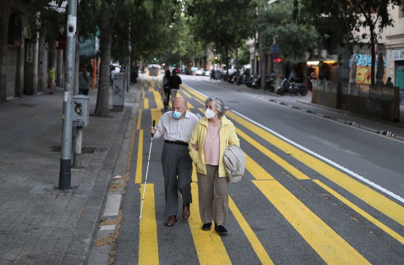 &copy; Reuters. FOTO DE ARCHIVO: Un matrimonio de ancianos con mascarillas pasea por Barcelona
