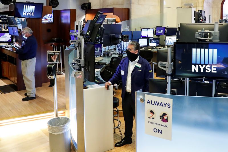 © Reuters. Traders wearing masks work, on the first day of in-person trading since the closure during the outbreak of the coronavirus disease (COVID-19) on the floor at the NYSE in New York