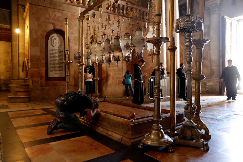 &copy; Reuters. Fiel reza na Igreja do Santo Sepulcro em Jerusalém