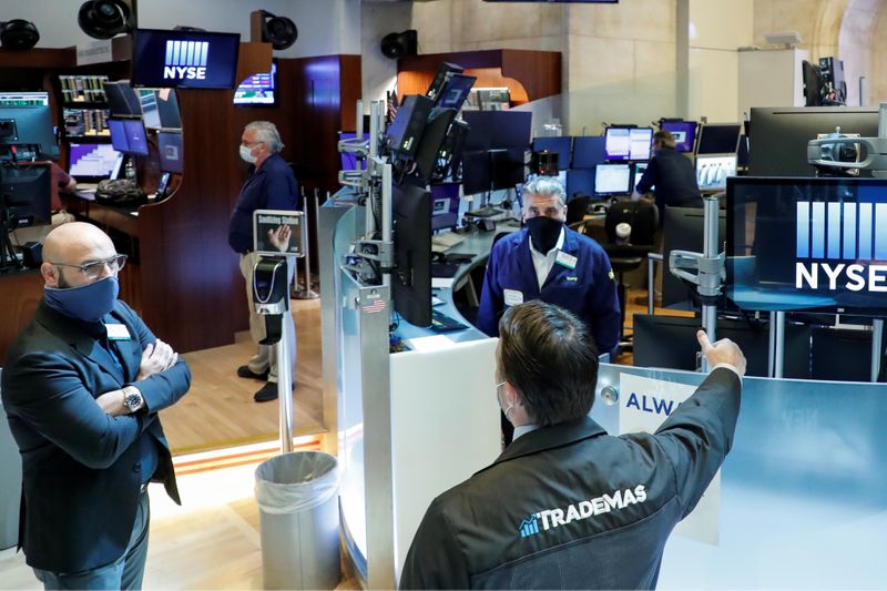 &copy; Reuters. Traders wearing masks work, on the first day of in person trading since the closure during the outbreak of the coronavirus disease (COVID-19) on the floor at the NYSE in New York