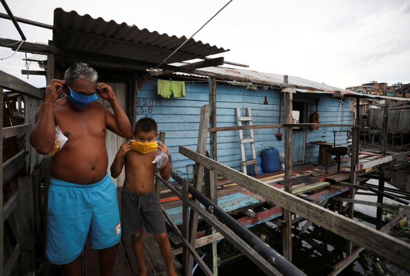 &copy; Reuters. Moradores de favela de Manaus colocam máscara para evitar contaminação pelo coronavírus