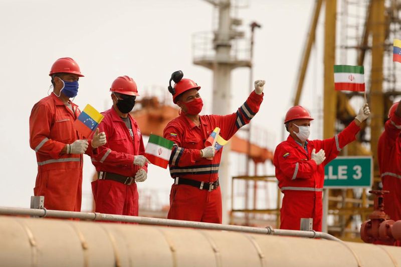 &copy; Reuters. FILE PHOTO: Workers of the state-oil company Pdvsa holding Iranian and Venezuelan flags greet during the arrival of the Iranian tanker ship &quot;Fortune&quot; at El Palito refinery in Puerto Cabello
