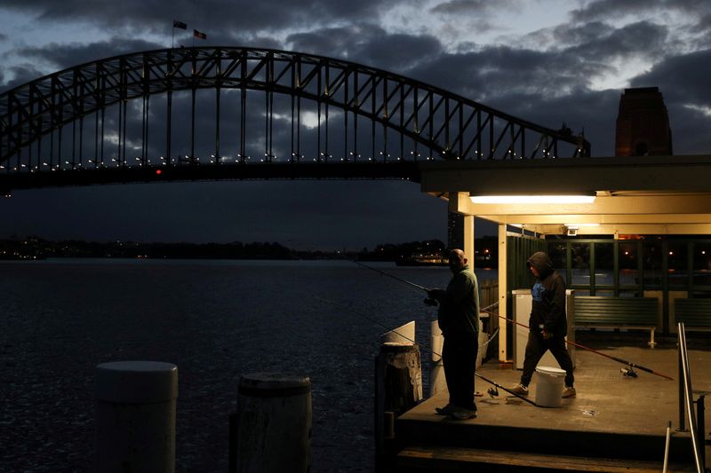 &copy; Reuters. FILE PHOTO: Men fish amidst the easing of the coronavirus disease restrictions in Sydney