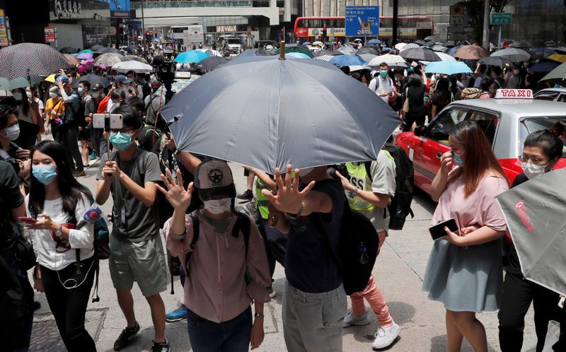 © Reuters. People wearing face masks take part in a protest against the second reading of a controversial national anthem law in Hong Kong