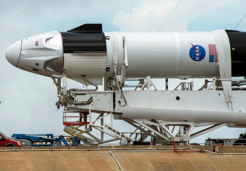 &copy; Reuters. Crews work on the SpaceX Crew Dragon, attached to a Falcon 9 booster rocket, as it sits horizontal on Pad39A