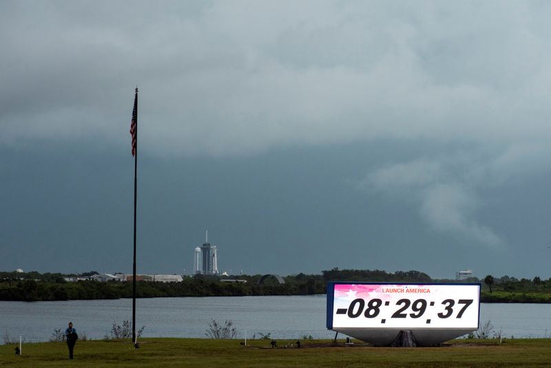 © Reuters. The SpaceX Crew Dragon, attached to a Falcon 9 booster rocket, stands beneath storm clouds on Pad39A