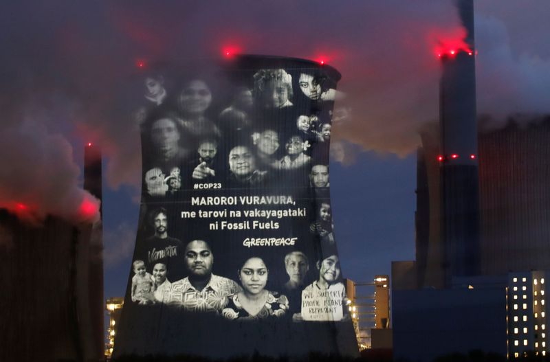 &copy; Reuters. Activists of the environmental organisation Greenpeace project a slogan that reads &quot;No Future in Fossil Fuels&quot;, on the cooling tower of RWE coal power plant, in Neurath