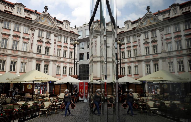&copy; Reuters. FILE PHOTO:   employee carrying flowerpots prepares an outdoor seating of a restaurant in Prague