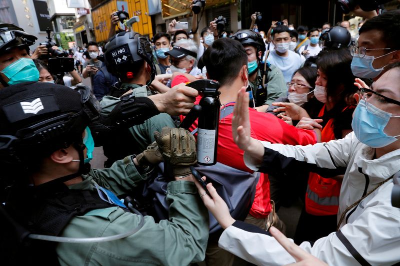 © Reuters. FILE PHOTO: Anti-government demonstrators scuffle with riot police during a lunch time protest as a second reading of a controversial national anthem law takes place in Hong Kong
