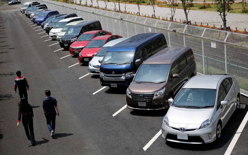 &copy; Reuters. FILE PHOTO:  People walk beside test-driving cars outside a car maker&apos;s showroom in Tokyo