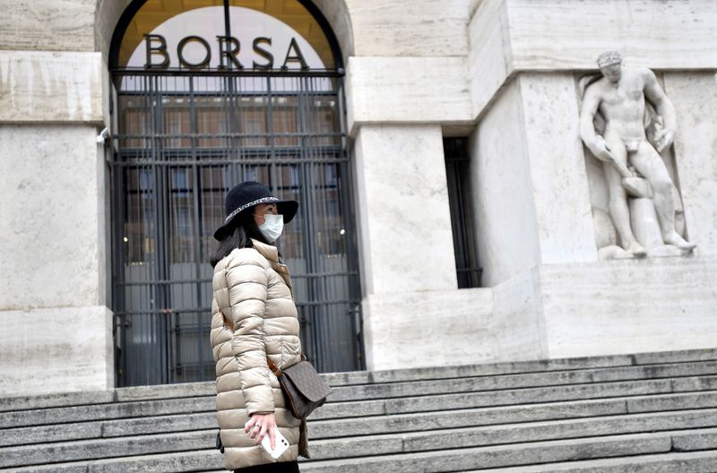 &copy; Reuters. FILE PHOTO: Woman in a face mask is seen in front of the Italian Stock Exchange in Milan